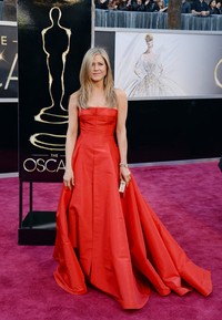 Jennifer Aniston tampil bak putri dengan gaun merah Valentino. Jason Merritt/Getty Images.