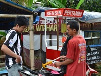 Seorang pengendara motor saat mengisi bensin di Pertamini (Foto Tri Yudianto).