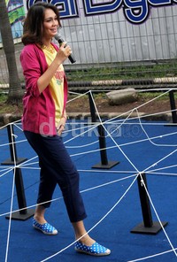 Dibalut kaus kuning, cardigan pink, celana dongker, dan sepatu biru motif polkadot, Luna Maya bergaya casual. Gus Mun/detikHOT.