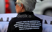 Para peserta aksi mayoritas mengenakan pakaian berwarna hitam.