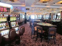 Ada banyak ruang entertaiment di dek 5, salah satunya ruang kasino. Meja-meja kasinonya berjejer rapi. Di kanan-kiri ruangan, ada jendela besar untuk melihat lautan dan ada juga meja Black Jack di sini. Kalau bermain di sini, harus pesan chip dulu (Afif/detikTravel)