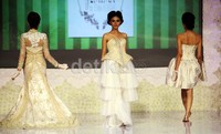 Tiga model berlenggak-lenggok mengenakan busana pengantin rancangan Emma Assegaf.