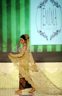 Seorang model berlenggak-lenggok di atas catwalk.