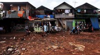 Sejumlah warga duduk-duduk di depan rumahnya di pinggir waduk di kawasan Jakarta.