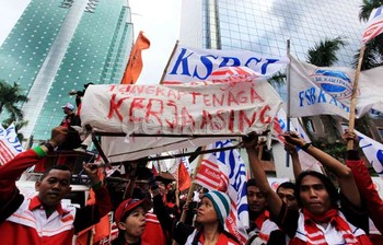     Buruh membawa keranda mayat bertuliskan sejumlah tuntutan.
