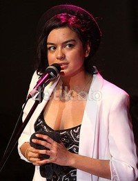 Eva cantik dibalut tanktop hitam motif, blazer putih, dan topi fedora.