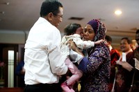 Dahlan Iskan (kanan), menggendong Habibatul Faseha, puteri dari Leni Haini (kanan),mantan atlet Perahu Naga yang kini bekerja sebagai buruh cuci di Jambi.