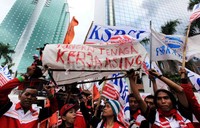 Buruh membawa keranda mayat bertuliskan sejumlah tuntutan.