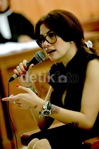 Kacamata juga melengkapi penampilannya.