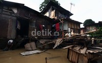 Meski rumah mereka terendam banjir, warga enggan mengungsi.