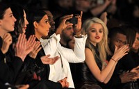 Kanye West terlihat mengabadikan fashion show tersebut dengan gadget-nya. Pascal Le Segretain/Getty Images.