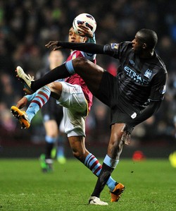Fabian Delph berebut bola dengan Yaya Toure. AFP/Paul Ellis.