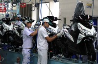 Sejumlah pekerja merakit Spacy Helm In PGM-FI yang memiliki striping dan warna baru. Konsep stripe terbaru Honda Spacy Helm in PGM-FI ini mengusung garis-garis yang tajam, sporti, dan atraktif. (dok Honda).