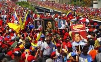 Warga memadati jalanan sambil membawa foto Hugo Chavez dan mengibarkan bendera Venezuela. Reuters/Carlos Garcia Rawlins.