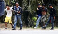 Polisi Malaysia menangkap dua pengikut Sultan Sulu di Tanjung Labian, sebuah desa yang berdekatan dengan Tanduo, Rabu (6/3/2013). Reuters/Bazuki Muhammad.