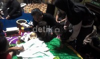 Ibu Fatir, Nurhikmah yang ditemani dua kakak Fatir mencium jenazah Fatir yang terbaring di hadapannya.
