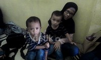 Dua kakak Fatir, yakni Fadel Muhammad dan Putra Muhammad hanya bisa terdiam di samping ibunya.