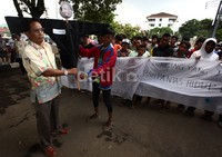 Salah seorang pendemo menyerahkan boneka bergambar Anas Urbaningrum kepada staf Kebun Binatang Ragunan.