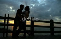 Sepasang kekasih menikmati suasana matahari terbenam di jembatan Le Bridge Ancol, Jakarta,