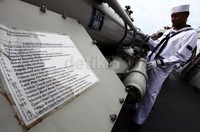 Salah seorang anggota TNI memantau menggunakan teropong dari atas kapal.