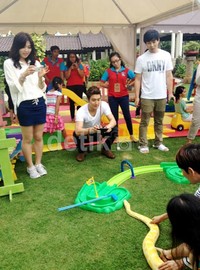 Siwon tampak santai mengenakan kaus putih dan celana hitam.