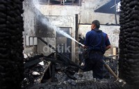 Petugas pemadam kebakaran memadamkan sisa api di perumahan di Jl Salemba Bluntas, Jakarta Pusat.