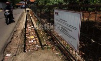 Tanah itu dipagari kawat. Segel KPK terpasang di pagar itu.