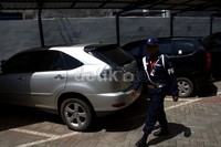 Petugas keamanan sedang memantau mobil Toyota Harrier B 8706 UJ dan Avanza B 1894 SKG yang disita KPK dari Irjen Djoko Susilo. Ramses/detikFoto.