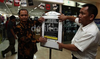 Direktur Penyidikan DJHKI Mochamad Adri (baju batik) dan Direktur II Tipideksus AKBP Rusharyanto (kanan) menempelkan poster tentang bahayanya software bajakan.