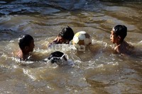 Empat orang anak tengah asyik bermain bola.