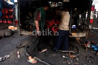 Dua orang mekanik mengecek mesin bus TransJakarta.
