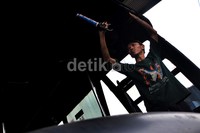 Seorang mekanik mengganti kaca depan bus.