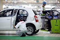 Seorang pekerja mengecek salah satu mobil yang telah selesai dirakit.