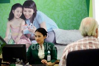 Salah seorang teller Bank Permata tengah melayani nasabah.