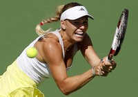 Caroline Wozniacki mengembalikan smash keras dari Maria Sharapova. Reuters/Danny Moloshok.