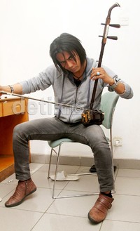 Charly tampak serius saat memainkan alat musik erhu. Gus Mun/detikHOT.