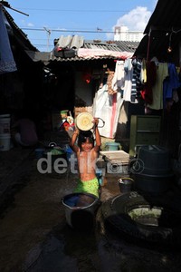 Seorang anak mandi di sebuah sumur di kawasan Petamburan, Tanah Abang, Jakarta.