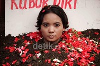 Beberapa pendemo yang lain juga menaburkan bunga di sekitar kepala Siti Hafsah.