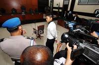 Rasyid sempat berdiri di sekitar kursi terdakwa.
