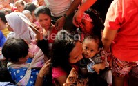 Seorang ibu juga mengajak anaknya untuk mengantre sembako.