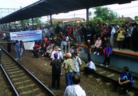 Para pendemo membentangkan spanduk menolak penghapusan KA ekonomi. (Candra Ganiawan).