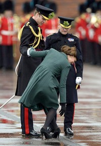 High heels Kate Middleton tersangkut di sela-sela jeruji penutup pembuangan air saat menghadiri acara St. Patrick's Day Parade di Aldershot, Inggris. AFP Photo/Adrian Dennis.