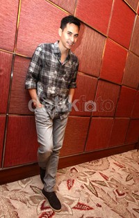 Ia tampil mengenakan kemeja kotak-kotak dan celana jeans abu-abu.