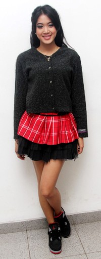Ia tampil mengenakan cardigan dan sepatu hitam serta rok merah. Gusmun/detikFoto.