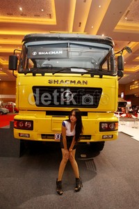 Seorang model berpose dengan truk Shacman.