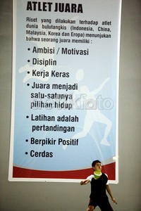 Atlet pelatnas bulutangkis tunggal putra Simon Santoso, tengah berlatih disamping spanduk besar bertuliskan motivasi Atlet Juara yang dipasang di pelatnas bulutangkis PBSI Cipayung, Jakarta Timur.