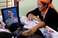 Istri AKP Andar Siahaan, Velegia Situmorang menangis di samping jenazah suaminya.