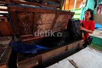 Seorang pedagang mengevakuasi barang dagangannya.