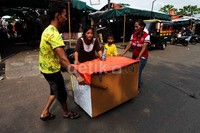     Tiga orang pedagang mengevakuasi gerobak dagangannya.