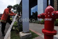 Seorang petugas pemadam kebakaran menyiapkan air untuk memadamkam api dalam simulasi penanganan bencana di Gedung PHE, Jakarta.